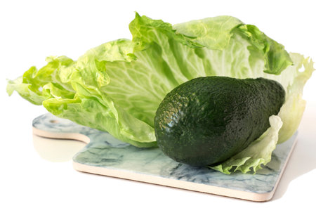 whole green avocado on the background of green iceberg lettuce