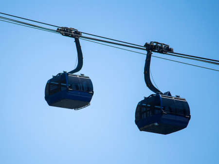two dark blue funiculars on a blue sky background.の写真素材