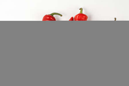 five red hot peppers lie on a white backgroundの写真素材