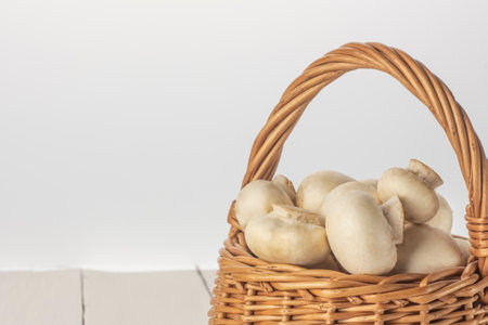 Champignons in a basket on a white background close-up with a copy of the space.の写真素材