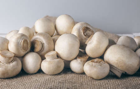 edible mushrooms champignons on the background of burlap.