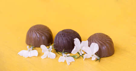 Chocolates with white flowers on a yellow background,の写真素材