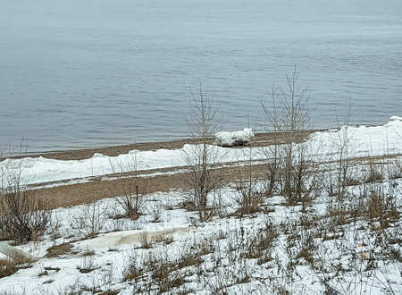a wide river with snow-covered banks in winterの写真素材