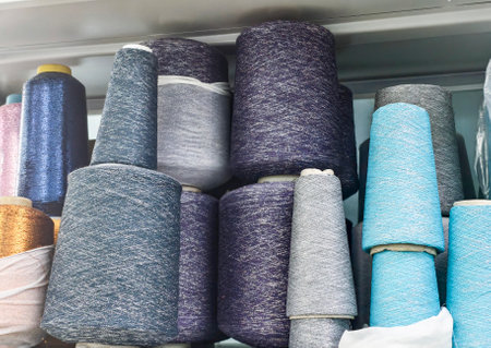 textile industry concept, bobbins of lurex yarn in different colors on a shelf