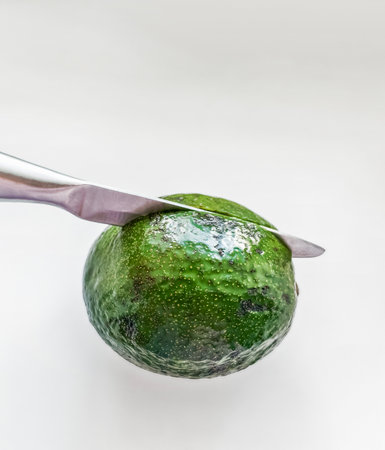 Fresh green avocado fruit with a knife, healthy eating concept