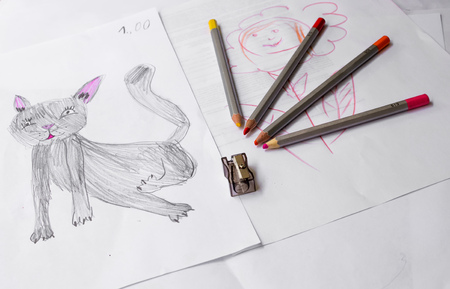 Children's drawing of a cat, color pencils and a sharpenerの写真素材