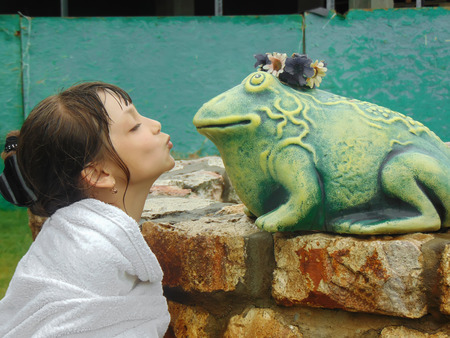 The girl is about to kiss the mock-up of the toadの写真素材