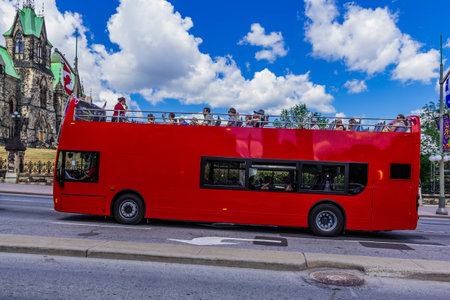  A red bus with tourists beside Parliament building on Parliament hill in Ottawa, Ontario, Canadaのeditorial素材