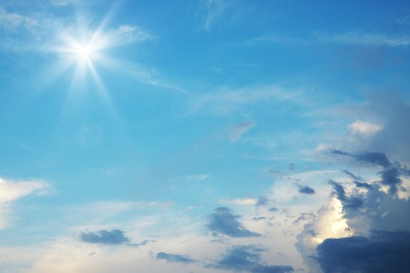 Bright sun in blue sky with clouds