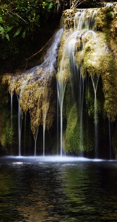 Beautiful waterfalls on the river following from a cave