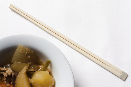 Japanese dish ( meat and potatoes ) with a pair of sticks.の写真素材