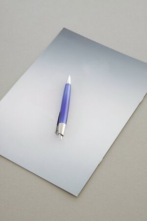 Blue Pen on a grey notebookの写真素材