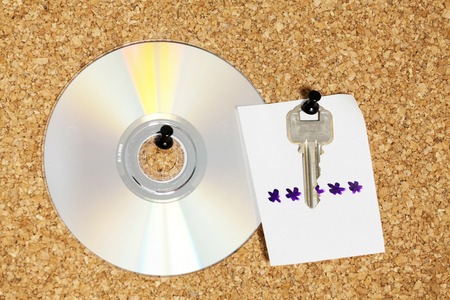 idea for key with note for password of CD over cork background