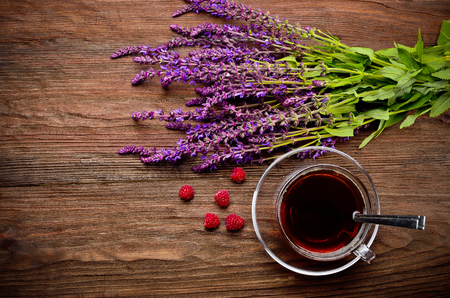 Tea, raspberry, flowers on a wooden tableの写真素材