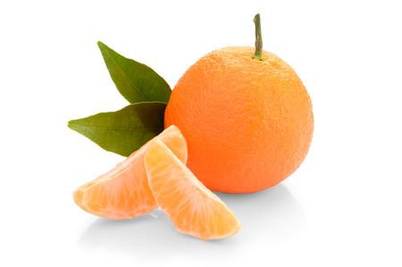 tangerine with slices and leaves on a white backgroundの写真素材