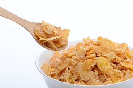 bowl of cornflakes with a spoon on white background. Healthy Eating. breakfast. vegetarianism.の写真素材
