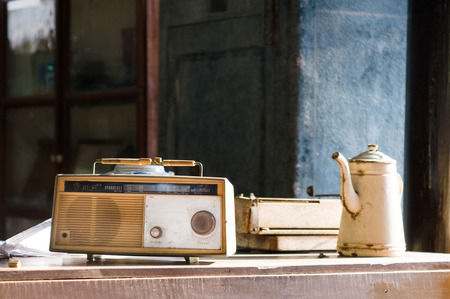 Vintage old radio receiver on wood table with pot and typewriter.の写真素材