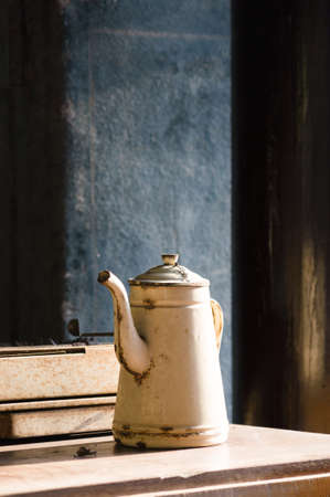 Vintage old tea pot on wood table with some book over wood table.の写真素材