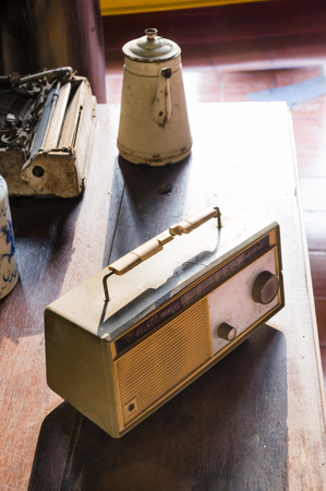 Vintage old radio receiver on wood table with pot in vintage house.の写真素材