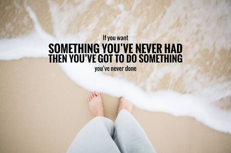 Inspirational quote on man feet step on sand that sea water splash to foot. show emotional moment.の写真素材