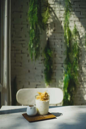 Dalgona coffee with milk and whipped cream on a white tableの写真素材