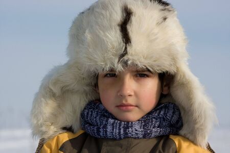 Cute little boy winter portrait in the fur-capの写真素材