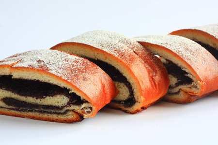 Poppy seed strudel sprinkled with sugar on a white backgroundの写真素材