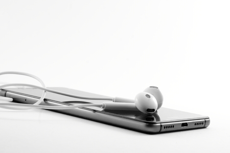 Mobile phone black and white headphones on a light backgroundの写真素材