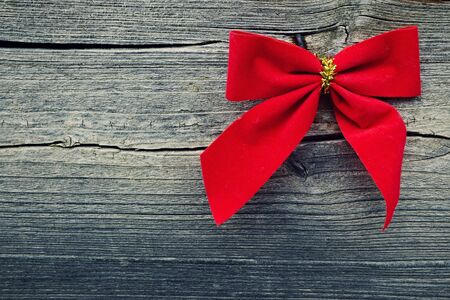 Red Christmas bow on a wooden background の写真素材