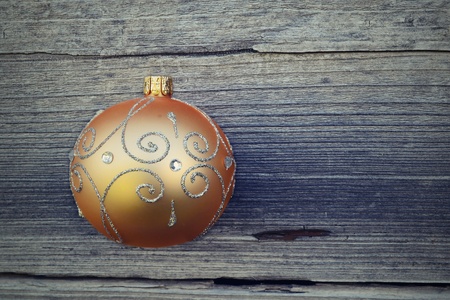 Golden christmas ball on a wooden backgroundの写真素材