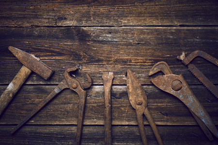 Grungy old rusted tools on a wooden background (processing cross-process)の写真素材