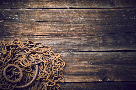 Tangle of rusty chains on wooden boardsの写真素材