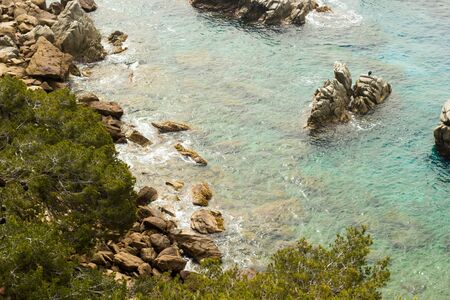 Sea rocks and waves in beautiful sunny dayの写真素材