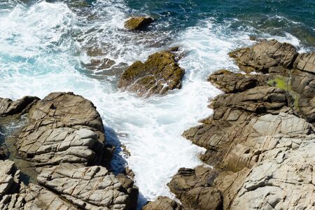 Sea rocks and waves in beautiful sunny dayの写真素材