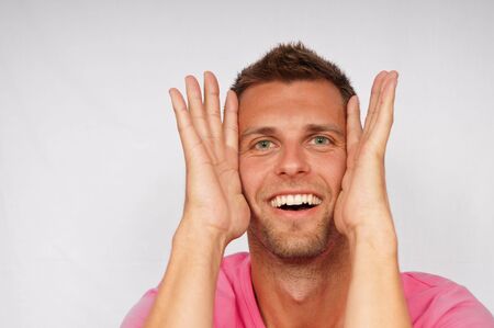 Young attractive man with hands on the faceの写真素材