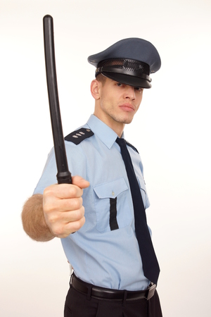 Angry policeman at shirt aand tie with police baton の写真素材