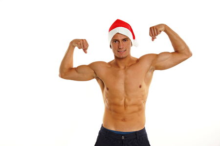 Atletic bronzed sexy Santa Claus poses on white backgroundの写真素材