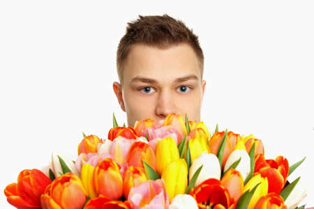 Face of young man with bouqet tulips の写真素材