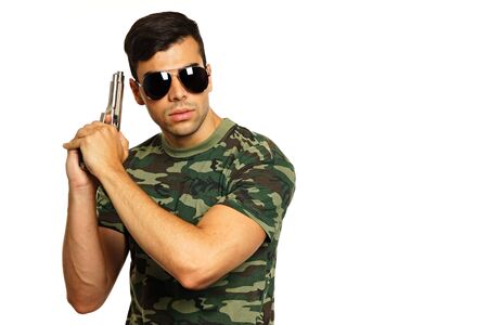 Young military man with a gun in hand on white backgroundの写真素材