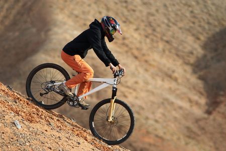 Girl downhill on mountain bike in red canyonの写真素材