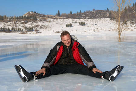Man resting on ice after riding on skatesの写真素材