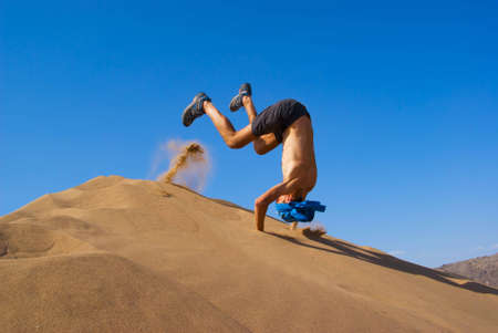 Fun jumping on sand duneの写真素材