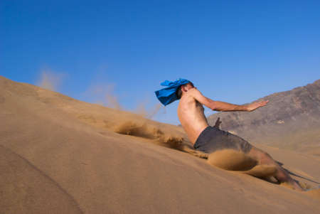 Fun jumping on sand dune - blurred motionの写真素材
