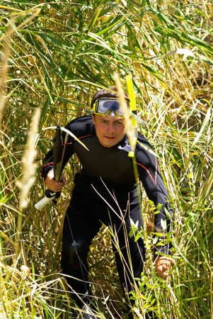 Underwater fisherman in bulrush beside lakeの写真素材