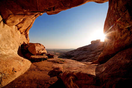 Entrance to cave and the sunset in desert mountainsの写真素材
