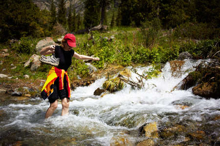 A woman barefoot in a shallow mountain creek.の写真素材
