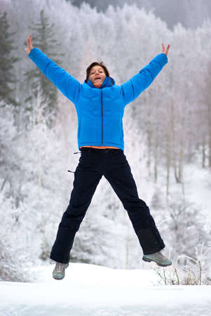 Jumping woman in winter forestの写真素材