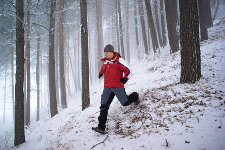 Blurred motion of running man in winter mountain forestの写真素材