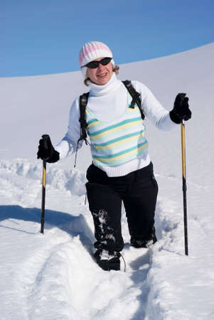 Smiling woman on a snow path in the mountainsの写真素材