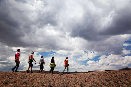 Group of tourists in the desert and storm cloudsの写真素材